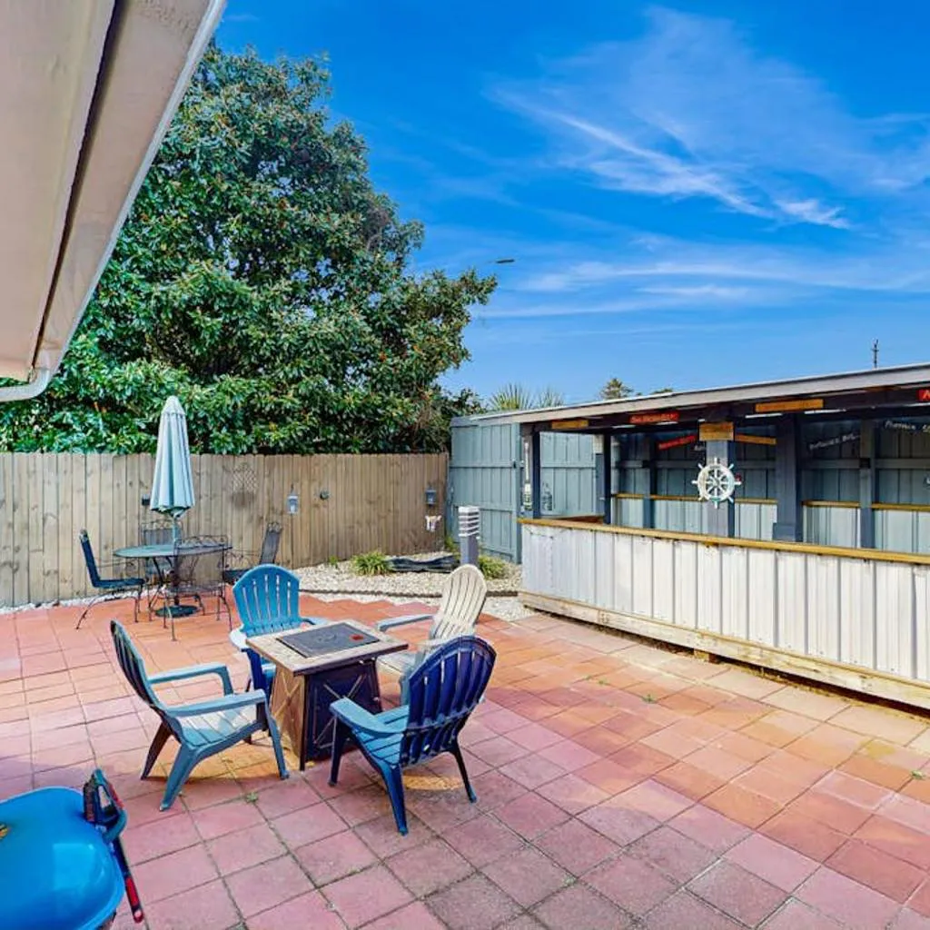 Photograph of Gorgeous coastal home with outdoor dining-living space & close to beach